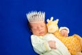 Cute newborn baby boy sleeping on a blue blanket with little toy Royalty Free Stock Photo