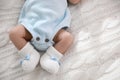 Cute newborn baby in crocheted booties on white knitted plaid, top view. Space for text Royalty Free Stock Photo