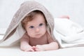 Cute newborn baby girl with beautiful blue eyes on a white terry coverlet. Adorable baby looking out under a white Royalty Free Stock Photo