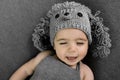 Cute newborn baby in the grey dog hat. Happy baby on a grey background. Closeup portrait of newborn baby. Baby goods packing