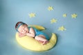 Cute newborn baby sleeping on a moon pillow Royalty Free Stock Photo