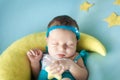 Cute newborn baby sleeping on a moon pillow