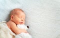 Cute newborn baby sleeps with toy teddy bear