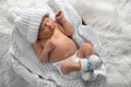 Cute newborn baby in warm hat and socks sleeping on knitted blanket, top view Royalty Free Stock Photo