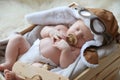 Cute newborn baby wearing aviator hat with toy sleeping in crate Royalty Free Stock Photo