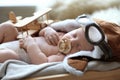 Cute newborn baby wearing aviator hat with toy sleeping in crate Royalty Free Stock Photo