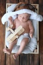Cute newborn baby wearing aviator hat in crate, top view Royalty Free Stock Photo