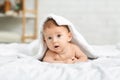 Cute newborn boy peeking out under soft white blanket Royalty Free Stock Photo