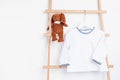 Cute newborn clothes hanging on the rack. Organic cotton baby apparel