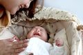 Cute newborn infant baby boy lying down on beautiful crib basket on bed, little child sleeping, mother gentle touching him, lovely Royalty Free Stock Photo