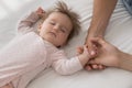 Cute newborn sleeping on bed touch loving parents hands Royalty Free Stock Photo