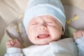 Cute nice little baby boy crying lying  on bed at home. Royalty Free Stock Photo
