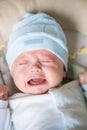 Cute nice little baby boy crying lying  on bed at home. Royalty Free Stock Photo