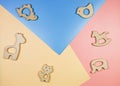 Cute nice small wooden baby teethers with different shapes on blue yellow pink background. Eco accessories for newborn.