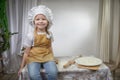 Cute oriental girl cooking in kitchen on Ramadan, Kurban-Bairam, Eid al-Adha. Funny female child at cook photo shoot