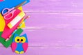 Cute owl decor, stationery. Coloured cardboard owl decor, scissors, glue stick, pencil, colored cardboard sheets on wooden table