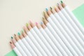 Cute pale color pencils on pastel green and ivory white paper ba