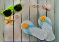 Cute, paper craft flip-flops that are ocean blue with sunny silk flower decoration. Summer decorations. Royalty Free Stock Photo