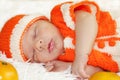Cute peaceful sleeping newborn baby dressed in a knitted orange Royalty Free Stock Photo