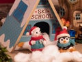 Cute penguin and polar bear mini figures are posing infront of a ski chalet