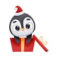 Cute penguin in Santa hat sitting in red gift box. Adorable funny baby bird cartoon character. New year and Christmas Royalty Free Stock Photo