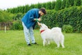 Caring owner of white husky calming his cute pet