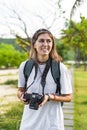 Cute photographer and travel blogger taking a photo with camera in summer