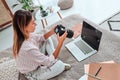 Cute photography girl on a bed. She look at the picture behind the digital camera