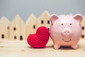 Cute pig smile with red heart on home village background for love community safe house concept