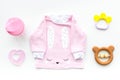 Cute pink baby clothes for girl. Shirt,, toy, bottle on white background top view Royalty Free Stock Photo