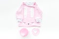 Cute pink baby clothes for girl. Shirt, toy, bottle on white background top view copy space Royalty Free Stock Photo