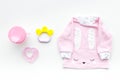 Cute pink baby clothes for girl. Shirt,, toy, bottle on white background top view Royalty Free Stock Photo