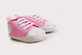 Cute pink baby girl sneakers close up on gray