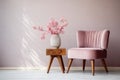 Cute pink flowers in glass vase placed on wooden table standing by small chair Royalty Free Stock Photo