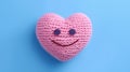 Cute pink handmade knitted heart on a blue background. Valentine\'s day concept.