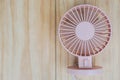 Pink portable USB fan on wooden frame for cool temperature