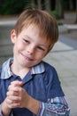Cute little boy smiles with malicious joy Royalty Free Stock Photo