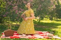 Cute plus size caucasian girl wearing a cute vintage yellow dress and enjoying a vacation in the summer Park on the green grass. c