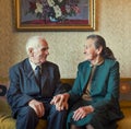 Cute 80 plus year old married couple posing for a portrait in their house. Love forever concept