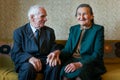 Cute 80 plus year old married couple posing for a portrait in their house. Love forever concept Royalty Free Stock Photo