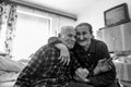 Cute 80 plus year old senior married couple hugging and smiling portrait. Black and white waist up image of happy elderly couple.