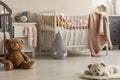 Cute plush toys and pink blankets in cozy bedroom interior for twin girls with two cribs and bedside cabinets. Real photo Royalty Free Stock Photo