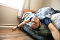 A Cute portrait of child upside down, lying on bed, smiling at camera and playing with toy