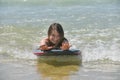 Cute portrait of a girl bodyboarding in the waves in summer