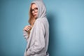 Cute positive blonde woman in gray hoodie and glasses