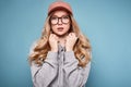 Cute positive blonde woman in a pink baseball cap