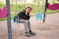 Cute positive boy teenager on the Playground in the city alone