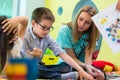 Pre-school boy learning to read helped by a dedicated kindergart