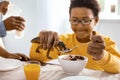 Cute pre-teen boy feeding toy dinosaur while playing with it Royalty Free Stock Photo