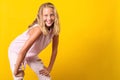 Cute pre-teen girl wearing fashion summer clothes posing on yellow background. 10 years old girl with beauty eyes, blonde hairl Royalty Free Stock Photo